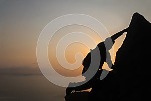 Silhouette of man climbing rock, Photographer on the mountain at sunrise