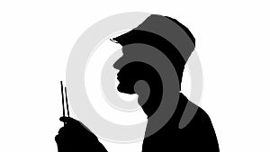 Silhouette of a man eating a bread straw on a white background. black and white mask