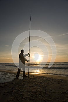 Silhouette of man fishing