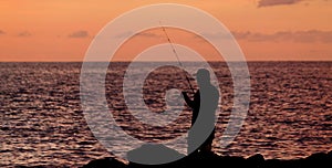 Silhouette of a man fishing