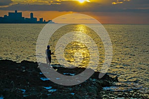 Silhouette of Man Fishing as Sunset