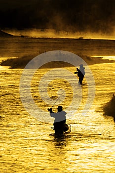 Silhouette of Man Flyfishing Fishing in River Golden Sunlight