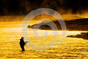 Silhouette of Man Flyfishing Fishing in River Golden Sunlight photo