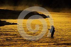 Silhouette of Man Flyfishing Fishing in River Golden Sunlight photo