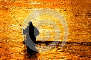 Silhouette of Man Flyfishing in River