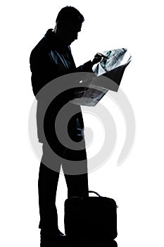 Silhouette man full length standing reading newspaper