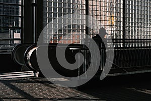 Silhouette of a man going down on an escalator