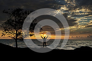 Silhouette of man with hands raised