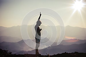 Silhouette of a man with hands raised in the sunset