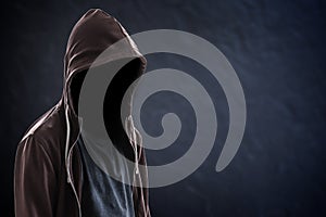 Silhouette of man with a hood, black background with copy space, criminal or hacker concept