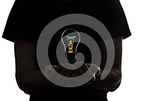 silhouette of a man with an incandescent glowing lamp in hand, thought bulb, concept of idea