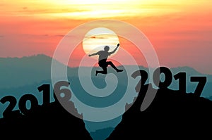 silhouette man jumps to make word Happy New Year 2017 with sunrise. (New Year 2017 is coming concept.)