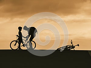 Silhouette man and kid with bicycle outdoor sport activity Father day Dad and Son