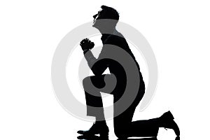 Silhouette man kneeling praying full length photo