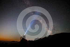 silhouette of a man with a lantern against the background of the starry sky with the milky way