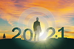 Silhouette man look to target the mountain  to 2021 years with the sunset or sunrise background. Happy and success growth with new