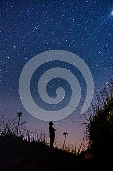 Silhouette of  man looking at the infinity of stars photo