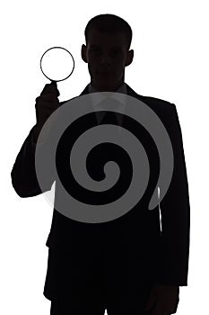 Silhouette of man with magnifying glass photo