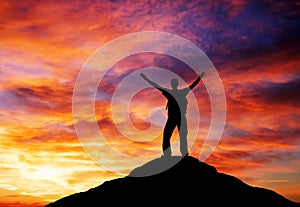 Silhouette of a man on a mountain top.