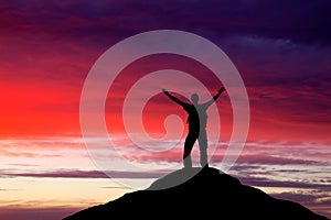 Silhouette of a man on a mountain top.