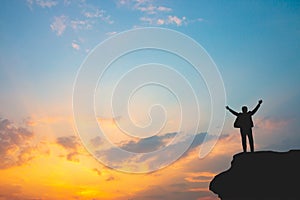 Silhouette of man on mountain top over sky and sun light background,business, success.