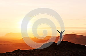 Silhouette of a man on a mountain top. Person silhouette on the rock. Sport and active life concept