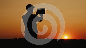 Silhouette of a man photographing sunset