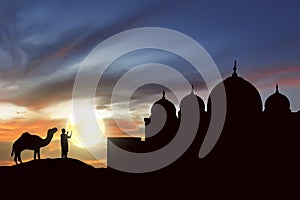 Silhouette man praying with camel outside the mosque