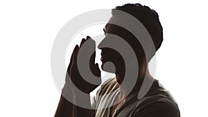 Silhouette of a man praying to God. Concept of faith and religion