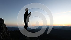 Silhouette of a man praying on top of a mountain, prayer of remembrance of god