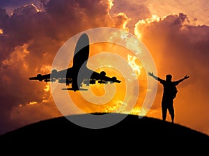 Silhouette the man raised up arms achievements successful and celebrate during airplane flying in sunset