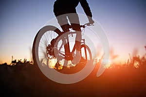 Silhouette of man riding bicycle in sunset