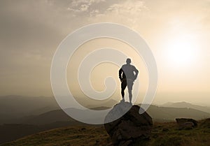 silhouette of a man on a rock at sunset