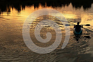 Silhouette of man rowing boat in wave lake water dark natural sunset background