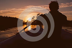 Silhouette of man rowing in sunset