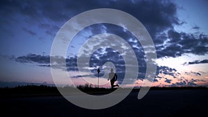 Silhouette of a man running on the road at sunset