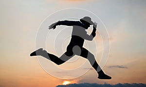 silhouette of man running in sense of freedom on sunrise sky, stamina