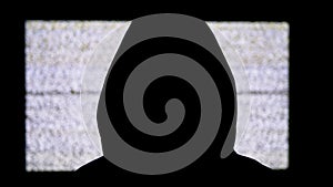 Silhouette of Man`s Head in Hood is Watching White Static Noise and TV Interference.
