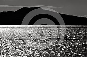 Silhouette of a man sea kayaking