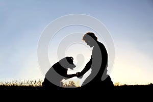 Silhouette of Man Shaking Hands with his Loyal Pet Dog