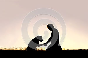 Silhouette of Man Shaking Hands with his Loyal Pet Dog