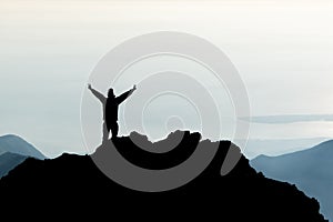 Silhouette of man spreading hand on top of mountain, Mount Rinjani, Lombok island, Indonesia