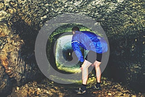 Silhouette of man stand in dark underground corridor. Light at end of tunnel