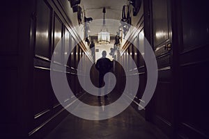 Silhouette of man standing in dark corridor in an old house.