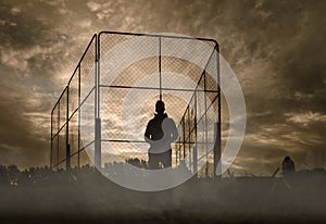 Silhouette of a man standing on sport field on foggy morning