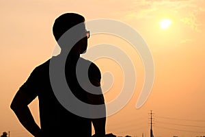 Silhouette of a man with sunglasses standing looking forward