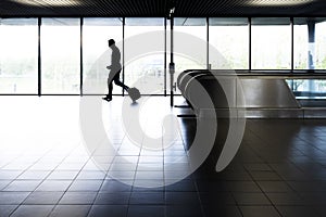 silhouette of a man walking in the airport corridor