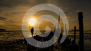 Silhouette of man walking on the beach at sunrise