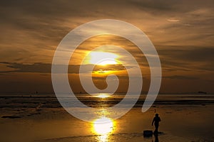 Silhouette of man walking on the beach at sunrise