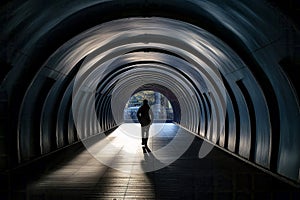 Silhouette of Man Walking at the End of Tunnel with Light